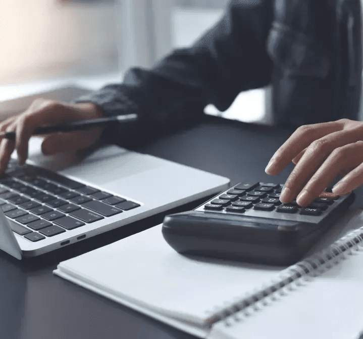 Persona trabajando en laptop con planos de construcción